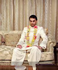 With a man wearing gray suit and woman. Latest Men Wedding Dresses Mehndi Barat Walima Collection 2021 2022