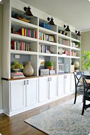 A dining room in white of mismatched chairs, floral walls and plate decors. Dining Room Built Ins Home Decor Home Bookshelves Built In