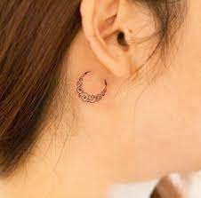 Delicate lines shading make the cherry blossom petals gracefully pop. Crescent Moon Tattoo By River Ear Tattoo Behind Ear Tattoos Tattoos