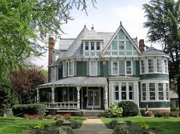 It has a carved wood entry door and a corner fireplace accented with framed photos. What You Need To Know About Victorian Style Homes