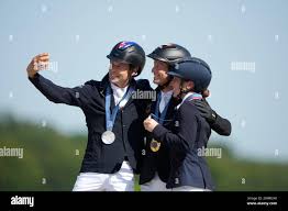 Australias Christopher Burton, Germanys Michael Jung and Britains Laura  Collett take a selfie while celebrating their medals in Equestrian Jumping  individual competition, at the 2024 Summer Olympics, Monday, July 29, 2024,  in