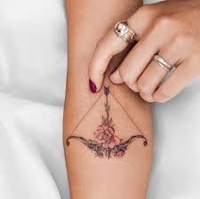 Small sagittarius zodiac bow symbol tattoo behind ear; 20 Sagittarius Tattoos Ideas Of 2020 Best Astrology Tattoos