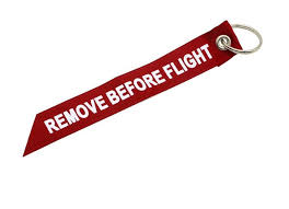 The phrase 'remove before flight' is something that most of us are familiar with, and it can be found on almost every travel gadget, from luggage tags and keyrings to travel socks and gifts for pilots, but there's much more to it than a fancy slogan. Remove Before Flight Ribbon Red Diecast Trading