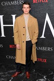 Burgundy or blue sweaters would look nice. Nicholas Galitzine Wearing Camel Overcoat Beige Crew Neck Sweater Black Dress Pants Burgundy Leather Chelsea Boots Lookastic