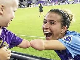 niño sin antebrazo saluda a una futbolista con la misma discapacidad