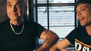 There is a tattoo made from a line which resembles two teeth with a gap between them on. X Factor S Robbie Williams Messes Up Tattoo On Louis Tomlinson S Arm As Pair Ink Each Other Ahead Of The Live Shows