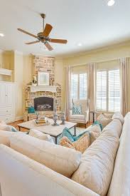A Brick Fireplace Pale Yellow Walls And Bright Blue Accents Give This Bright And A Yellow Decor Living Room Yellow Living Room Traditional Design Living Room