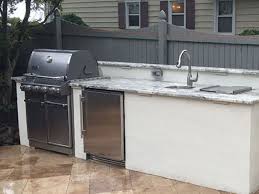 By combining a bar counter and chairs with the grilling station, everyone can visit while the food is sizzling. Salisbury Md Custom Outdoor Kitchen Design Build Weber Danver