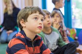 Children sitting and listening in classroom stock photo