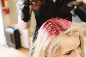 Blonde hair has been known to turn orange when it is washed with well water, which is more likely to have rust in it. Female Hair Colorist In Gloves Applying Red Hair Dye To Client Blonde Hair With Brush Coloring Hairstyle Stock Photo 192690470