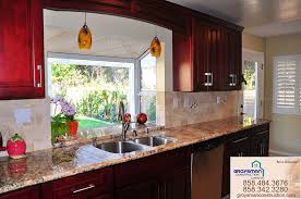 Cherry cabinets and white wall in the kitchen is a great choice. Dark Cherry Cabinets With Zeus Granite In San Diego