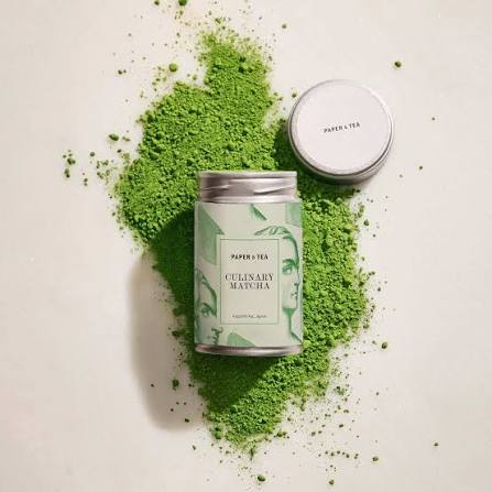 Vibrant green matcha powder in a bowl with bamboo whisk - key ingredient for matcha black sesame mug cake recipe