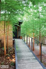 ทางเด นเข าบ านออกแบบให เป นทางลาดค อยๆ ปร บระด บความส งข นเร อยๆ ช วยให เด นข นได ง าย ปล กต นไม ทรงส งแผ ก งก านสวยงามอย างต นสนไว บ าน ภาพ ประเทศไต หว น