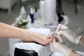 Woman Receiving Cuticle In Manicure Pedicure Salon Stock Photo