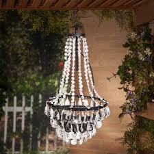 Crafted from metal in a neutral finish, this lantern features a domed roof topped with a tiered finial, tasteful moldings, and a hexagonal frame. Outdoor Chandelier Target