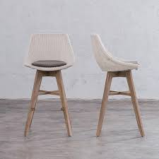 This bar stool's seat is woven of natural rattan and the frame is handmade of wood. Lecco Hampton Inspired Rattan Woven Bar Chair Noosa Dining Chair Living By Design