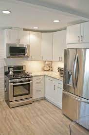 Set off crisply by the brown cabinets, the pendant lights are almost sculptural. Finished Kitchen Kitchen Remodel Small Small White Kitchens White Ikea Kitchen