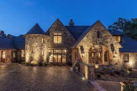 Stone house front with large grated. Traditional 2 Story French Provincial Stone House