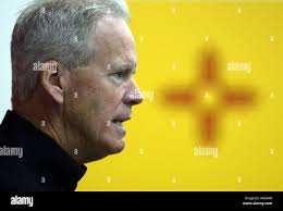 New Mexico coach Bob Davie, left, indicates instructions to his players  from the sideline during the first half of an NCAA college football game  against Utah State
