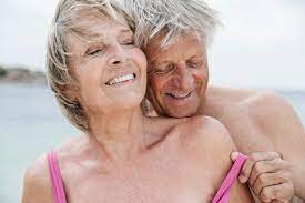 Spain, Senior couple undressing on beach stock photo