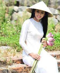 When Travelling Throughout Vietnam Tourists Never Fail To Take Notice Of The Local Charming Ladies Donned In Ao Dai Ao Dai Vietnamese Clothing Vietnam Dress
