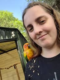 Could someone please remove the peanut shells from my shoulder? The bird  was very messy but I really like this photo of us