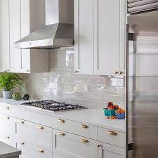 When using a chimney hood, always leave at least 2 to 3 inches between the hood and the wall cabinets to the left and right. Glossy Gray Kitchen Backsplash Tiles Design Ideas