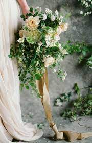 The big day is coming and it's time to make a decision on wedding flowers. Cascading Lines And Plenty Of Foliage Finished With An Antique Gold Ribbon For Just A Dash Of Color Wedding Flowers Wedding Bouquets Wedding