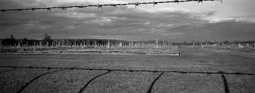 You can pronounce this inscription as: En Fotos Auschwitz Simbolo Del Terror Del Holocausto La Voz