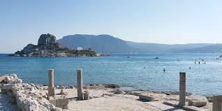 Een georganiseerd strand met voor de kust het eilandje kastri en de van foto's bekende blauwwitte kapel. Ruinen Der Basilika Agios Stefanos Vistagram Net