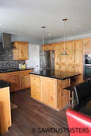 Beadboard panel with coat hangers sit below upper cabinets. From Knotty Alder To Light Grey Kitchen Cabinets Sawdust Sisters