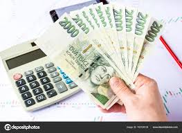 A Hand Holding A Lot Of Money Over The Charts Stock Photo