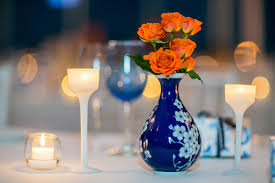 Whimsical wonderland weddings is all fresh and vibrant with this pretty blog post for you this royal blue and orange wedding inspirations for july 2019, white bridal gown, royal bridesmaid dresses and orange bouquets, jars filled with orange. Vibrant Orange Roses In Navy Blue And White Floral Vase Photo By Sarah Tew Photography Wedding Inspiration Board Junebug Weddings