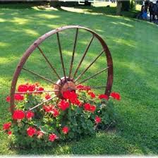 Wagon Wheel Ive Seen These At Garden Ridge Maybe I Could Doe Something Like This Near The Fence Or Driveway Garten Ideen Vorgarten Landschaftsbau Vorgarten