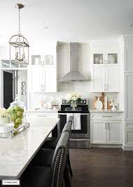 Industrial loft kitchen with black countertops, black cabinet hardware, black range hood and black stunning luxury kitchen with black cabinets, countertops all around a gray flagstone fireplace. White And Grey Kitchen A Hardware Update Citrineliving