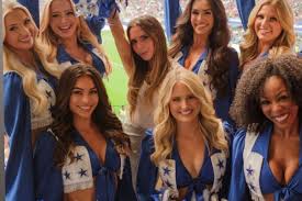 Victoria Beckham cracks a smile as she poses with cheerleaders after 'grumpy' World Cup snap