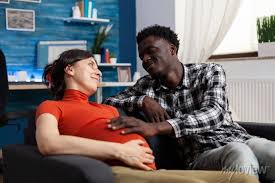 Interracial couple expecting child and parenthood at home. african &bull; wall  stickers family, table, apartment | myloview.com