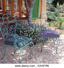 Rounded chair or stool cushion for industrial modern and farmhouse metal chairs and stools (tolix, tabouret, osp, adeco) Checked Cushions On Ornate Blue Metal Chairs On Cobble Paved Shady Seating Area In Garden Of French Country House Stock Photo Alamy