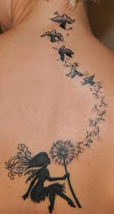 Tatouage Femme Dos Avec Fee Soufflant Sur Une Fleur De Pissenlit Et Oiseaux Vers La Nuque Tatouage Femme