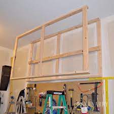 Learn how to build simple, cheap garage storage shelves that use the wasted space above your garage door! Diy Garage Storage Ceiling Mounted Shelves Giveaway