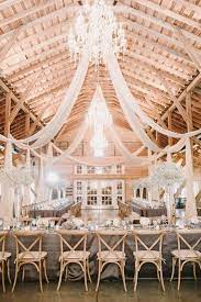 Barn Wedding Reception Decor Idea Barn Venue With Chandeliers Draped Fabric Gray Table L Barn Wedding Reception Wedding Reception Decorations Barn Wedding