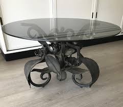 Gold leafed with a marble top, painted black with a fabulous eglomise top, have a wood or even a poured concrete top made to give it your own. Rare Midcentury Wrought Iron Leaves And Flowers Coffee Table With Round Glass Top For Sale At 1stdibs