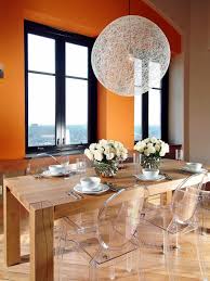A Rustic Wooden Table Combined With Iconic And Nearly Invisible Louis Ghost Chairs Creates An Ghost Chair Dining Room Eclectic Dining Room Orange Dining Room