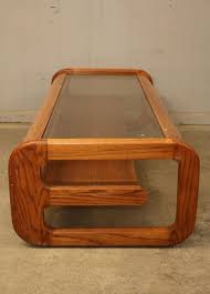 Light wood stain with rounded edges, metal inner leg brackets, turned legs and rounded molding under top. Absolute Auction Realty