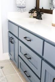 This contemporary vanity design is a nice juxtaposition to the heavily patterned wallcovering in this small but mighty bathroom. Painted Furniture Ideas 7 Mistakes People Make When Picking Out Cabinet Hardware Painted Furniture Ideas
