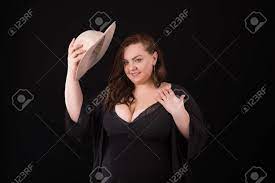 Beautiful Fat Woman With Big Breasts In A Jacket And Hat. Overweight. Plus  Size Or XXL Model Trying On Hat On Black Background Stock Photo, Picture  and Royalty Free Image. Image 121171417.