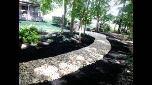 With larger river rocks, dig a portion of the rock into the ground for a more natural look. Installing River Rock To Solve Some Landscape Problems Youtube