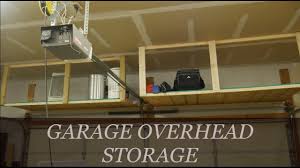These overhead hanging storage shelves hide the mess with sliding doors! Easy Diy Overhead Garage Storage Rack Youtube