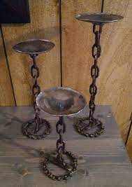 The slender silhouette of each candle holder is sculpted from aluminum and finished in black with subtle imperfections that allude to their artisanal craftsmanship. Chain Candle Holders Recycled Metal Steel Candle Holders Chain Decor Upcycled Decor Set Of 3 Candle Holders Candles Candlesticks Rustic Metal Candle Holders Metal Candle Metal Candle Holders