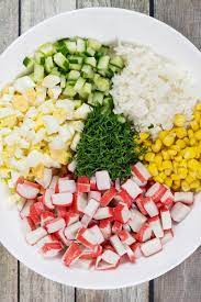 These imitation crab recipes are easy, delicious, and affordable! Check Out This Russian Version Of The Imitation Crab Salad Featuring Corn Rice Eggs And Cucumbe Crab Salad Recipe Crab Recipes Healthy Imitation Crab Salad